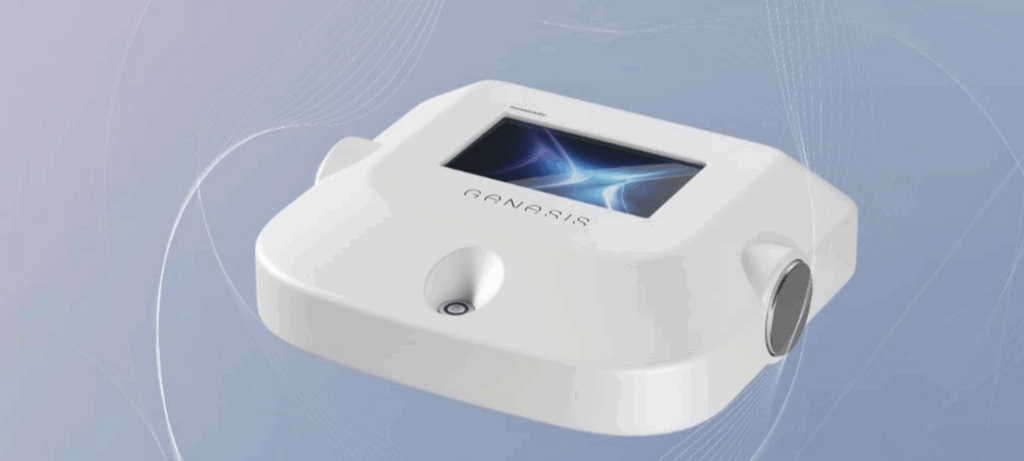Appareil médical ou esthétique blanc portant le nom GANASIS, avec un écran numérique et des connecteurs latéraux, sur fond bleu dégradé et abstrait.